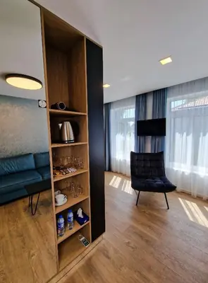a room with a book shelf and a chair in a room at Editos apartamentai in Jurbarkas