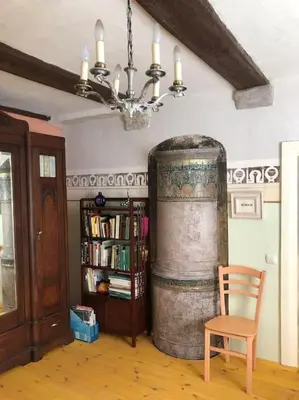 a room with a chair and a large barrel at Tranquil country cottage with outdoor fireplace in Stelmužė