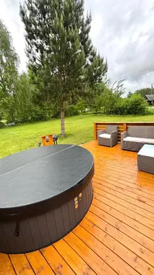 a wooden deck with a table and chairs and a tree at Chill House in Anykščiai