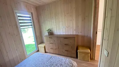 a bedroom with a bed and a dresser and a window at Chill House in Anykščiai