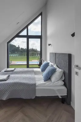 a bedroom with a large bed with a large window at MINDAUGO VILOS in Piliuona