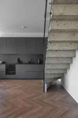 a kitchen with a staircase in a room with wooden floors at MINDAUGO VILOS in Piliuona