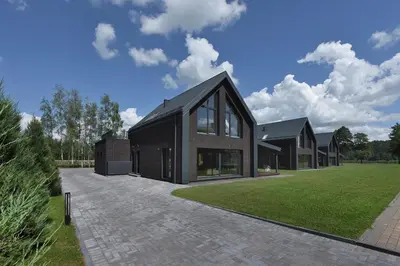 a large black house with a grass yard at MINDAUGO VILOS in Piliuona