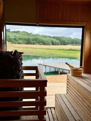 a view of a lake from a cabin with a large window at MINDAUGO VILOS in Piliuona