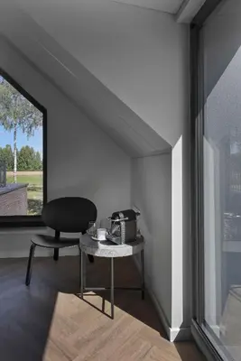 a chair and a table in a room with a window at MINDAUGO VILOS in Piliuona