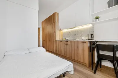 a small bedroom with a bed and a kitchen at Air Apartments - Code entry only, No staff in Vilnius