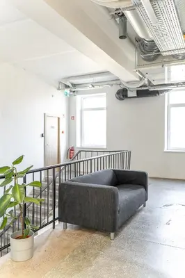 a black couch in a room with a staircase at Air Apartments - Code entry only, No staff in Vilnius