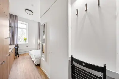 a white room with a bench and a window at Air Apartments - Code entry only, No staff in Vilnius