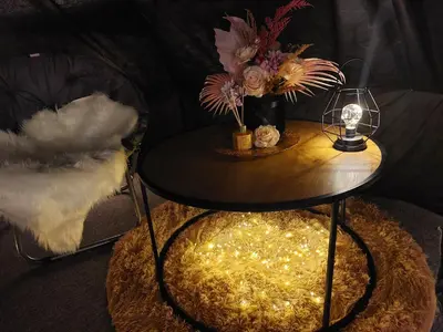 a table with a vase of flowers and a lamp at Glamping in - luxury tent in Šunupis