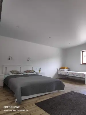 a white bedroom with a bed and white walls at Domo Vila in Druskininkai