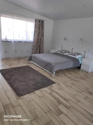 a bedroom with a bed and a wooden floor at Domo Vila in Druskininkai