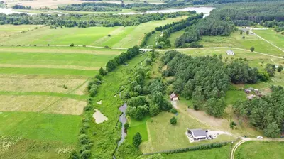 an aerial view of a field with a house and trees at Domo Vila in Druskininkai
