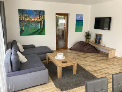 a living room with a couch and a table at Domo Vila in Druskininkai