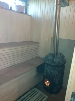 a wood fired stove in a room with a bench at Namas su terasa in Vilnius