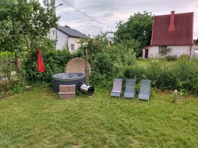 a group of three chairs and a barrel in a yard at Namas su terasa in Vilnius