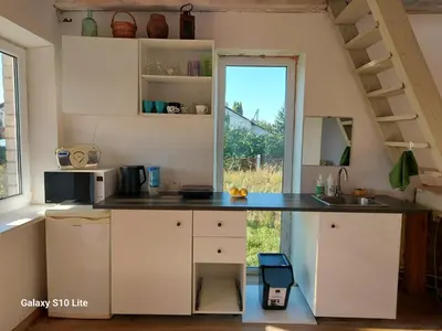 a kitchen with a counter with a sink and a window at Namas su terasa in Vilnius