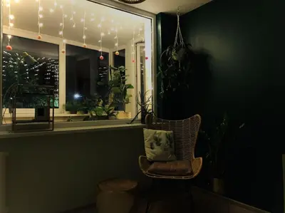 a chair in a room with a window with lights at Three bedroom with two terraces for 7people+baby in Kaunas