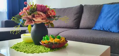 a vase with a bouquet of flowers on a table at Krymo g. Lovely 2 room flat in Šiauliai, near Akropolis in Šiauliai