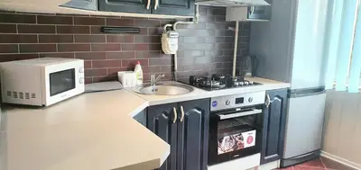 a small kitchen with a sink and a microwave at Krymo g. Lovely 2 room flat in Šiauliai, near Akropolis in Šiauliai