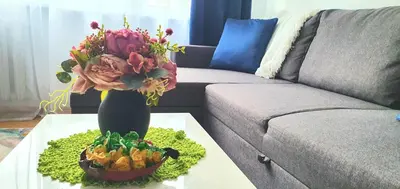 a vase with a bouquet of flowers on a table at Krymo g. Lovely 2 room flat in Šiauliai, near Akropolis in Šiauliai