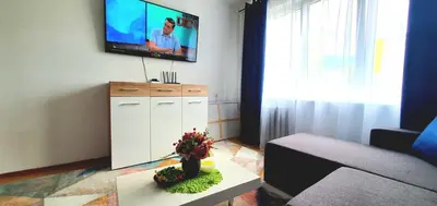 a living room with a couch and a tv on the wall at Krymo g. Lovely 2 room flat in Šiauliai, near Akropolis in Šiauliai