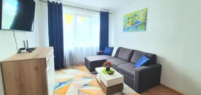 a living room with a couch and a table at Krymo g. Lovely 2 room flat in Šiauliai, near Akropolis in Šiauliai