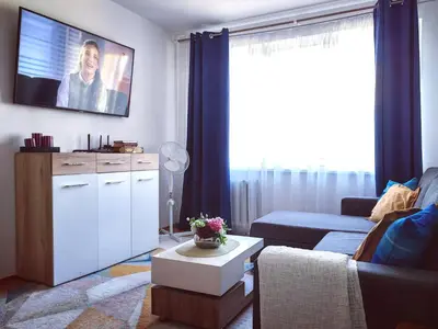 a living room with a couch and a tv on the wall at Krymo g. Lovely 2 room flat in Šiauliai, near Akropolis in Šiauliai
