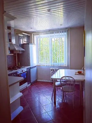 a kitchen with a table and chairs and a window at Krymo g. Lovely 2 room flat in Šiauliai, near Akropolis in Šiauliai