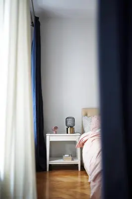 a room with a bed and a night stand next to a side table at Old town, Bright, Peaceful, Balcony, Netflix in Vilnius