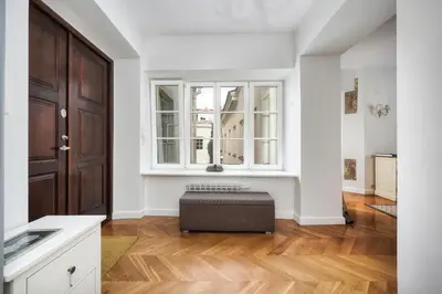 a living room with a large window and a ottoman at Old town, Bright, Peaceful, Balcony, Netflix in Vilnius