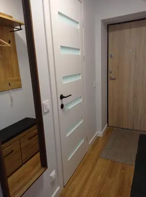 a door leading to a hallway with a wooden floor at TIMO butas in Druskininkai