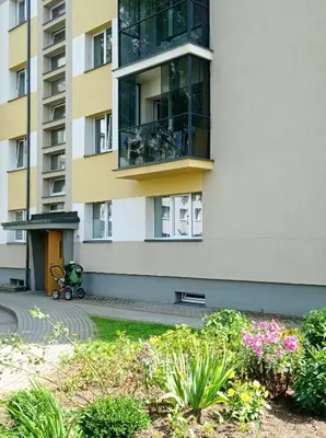 a building with a flower garden in front of it at TIMO butas in Druskininkai