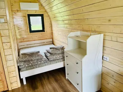 a tiny house with a bed in the middle at Palūšės Kempingas (nameliai) in Palūšė