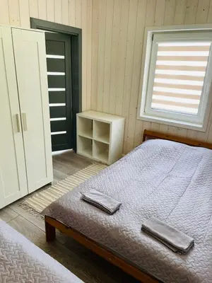 a bedroom with a bed with two towels on it at Palūšės Kempingas (nameliai) in Palūšė