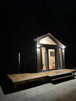 a tiny house on a platform in the dark at Palūšės Kempingas (nameliai) in Palūšė