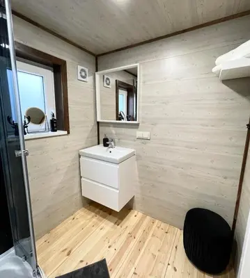 a bathroom with a white sink and a mirror at Palūšės Kempingas (nameliai) in Palūšė