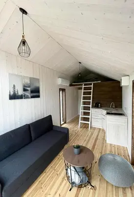 a living room with a couch and a table at Palūšės Kempingas (nameliai) in Palūšė