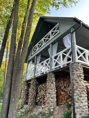 a tree house built on a pile of logs at Kumpuolis LakeHouse in Degučiai
