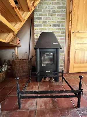 a stove in a room with a brick wall at Kumpuolis LakeHouse in Degučiai
