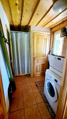 a bathroom with a washing machine in a house at Kumpuolis LakeHouse in Degučiai