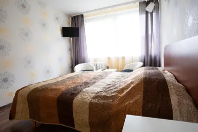 a bedroom with a bed with chairs and a window at Silvana in Vilnius