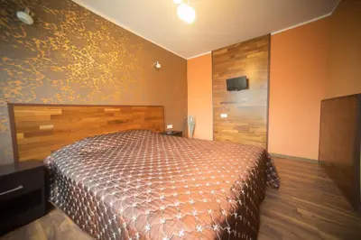 a bedroom with a bed with a wooden head board at Silvana in Vilnius