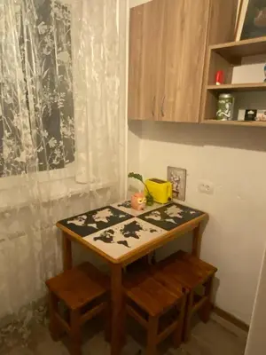 a small kitchen with a table and two stools at Įdomus būstas ant Neries skardžio in Vilnius