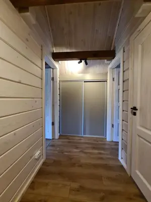 a hallway of a house with wooden walls and a door at Rubikių Meldynas Anykščiai in Anykščiai