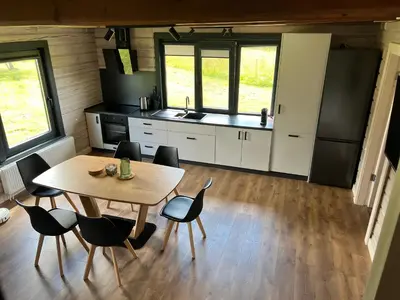 a kitchen with a table and chairs in a room at Rubikių Meldynas Anykščiai in Anykščiai