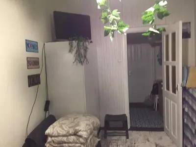 a room with a refrigerator and a chair in it at Studija virš cukrainės Druskininkuose in Druskininkai