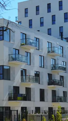 a tall white building with balconies on it at Brand New and Modern 1BDR Apartment in Vilnius