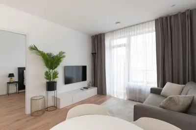 a living room with a couch and a tv at Brand New and Modern 1BDR Apartment in Vilnius