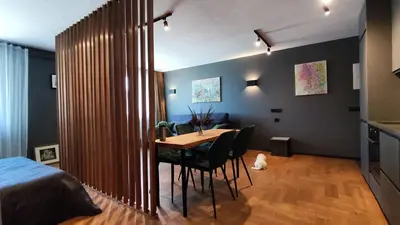 a room with a table and chairs and a bed at Dabintos Apartament Druskininkai in Druskininkai