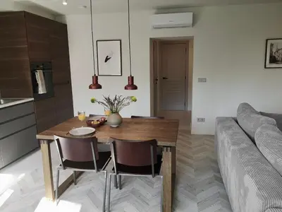 a kitchen and living room with a wooden table and chairs at Hill Top apartment in central Kedainiai in Kėdainiai